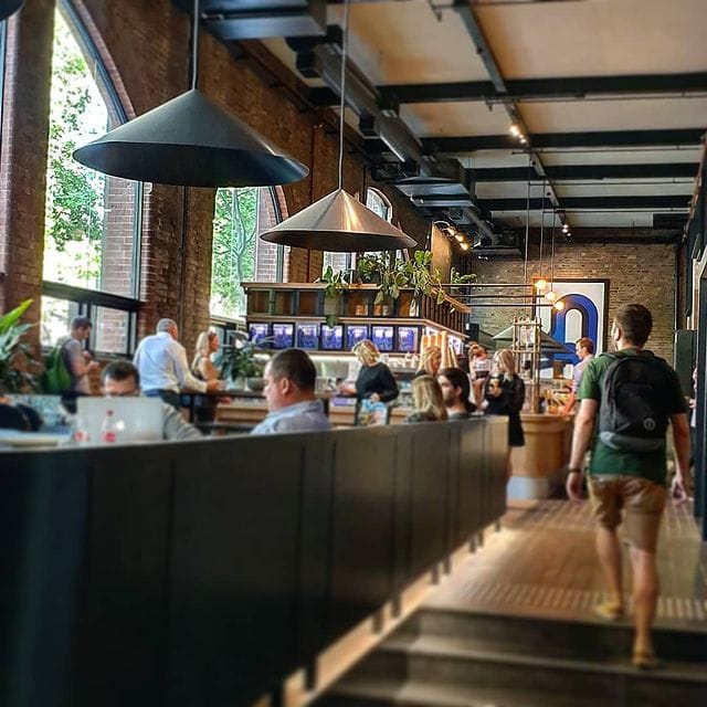 Inside Stockroom Cafe Pyrmont, exposed brick and timber tables in the heritage Old Wool Shed at 100 Harris Street